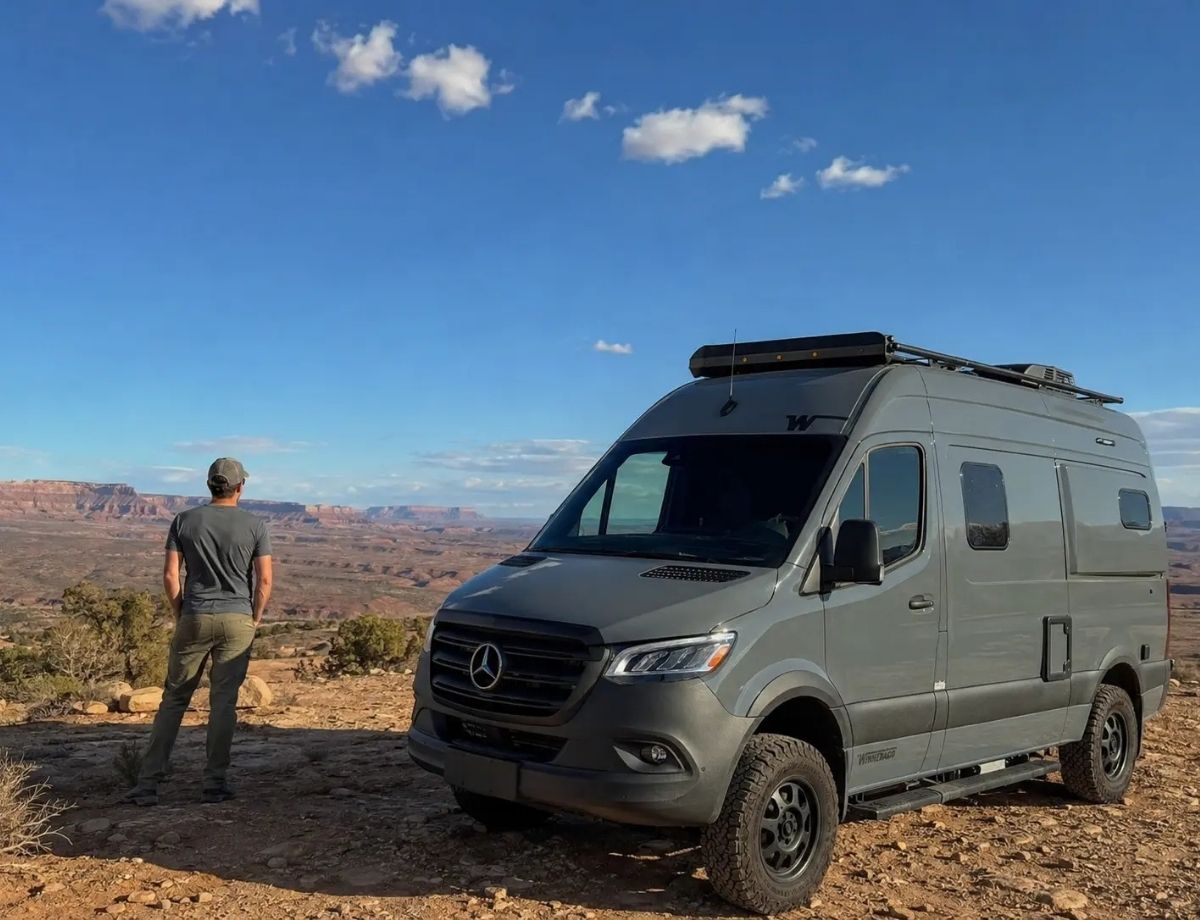 Mobile RV repair technician standing beside a fully equipped service van in Salt Lake City